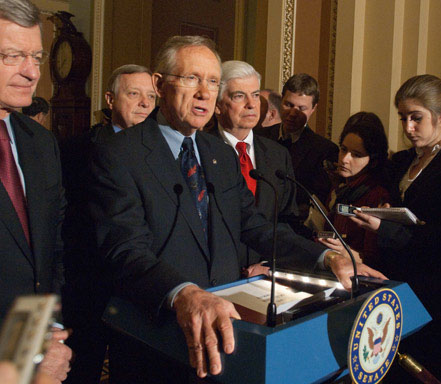 Reid, with Finance Committee chairman Max Baucus at his right hand, holds press conference upon the Dec. 24, 2009 passage of the Affordable Care Act.